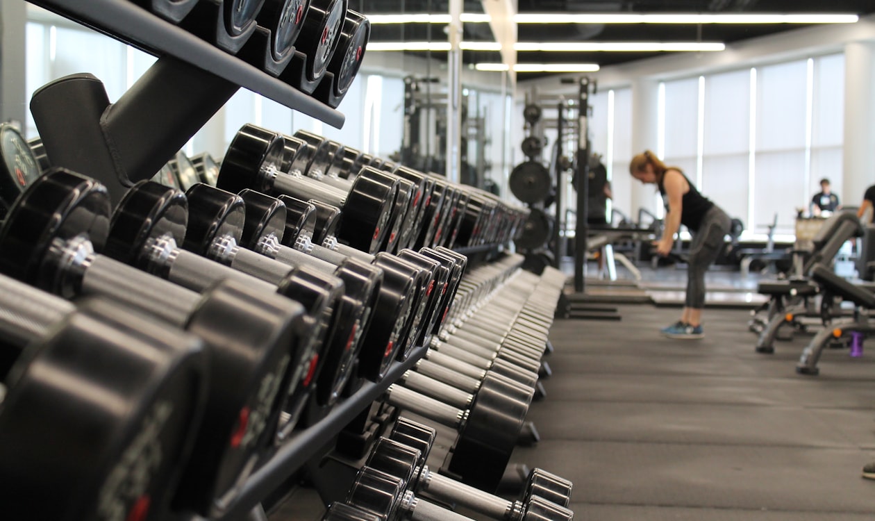 Row of dumbbells on a rack inside a modern gym with fitness equipment
