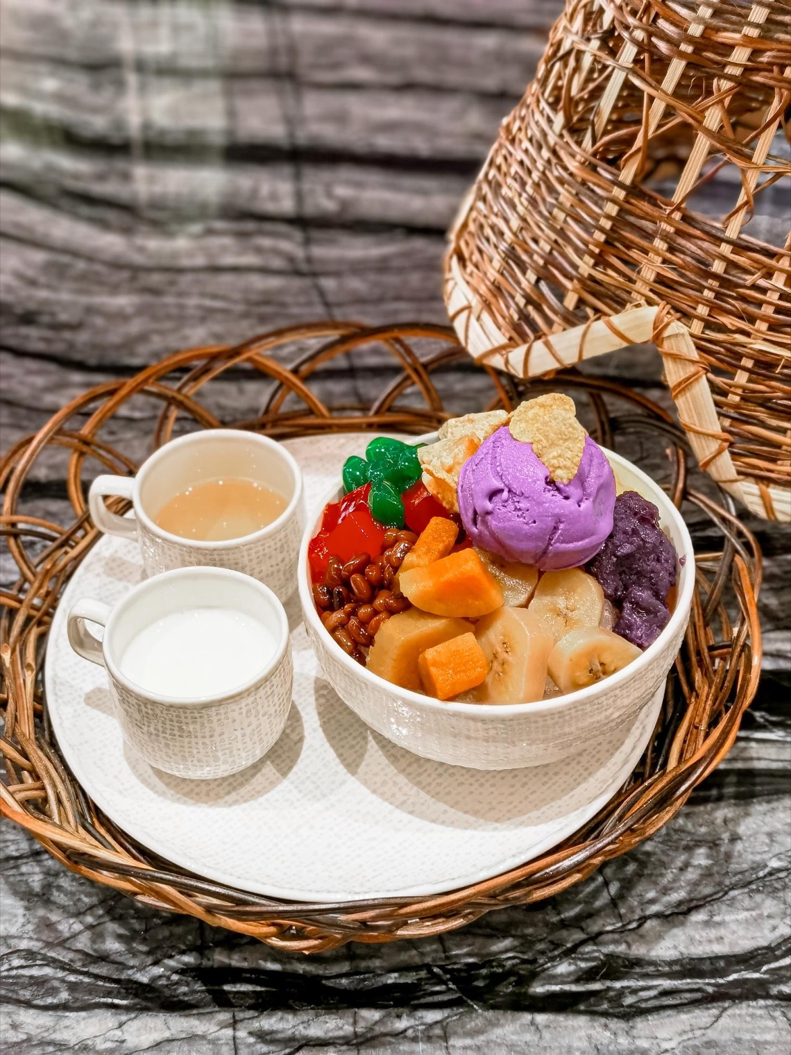 Colorful Filipino halo-halo dessert with ube ice cream, beans, fruits, leche flan, and evaporated milk