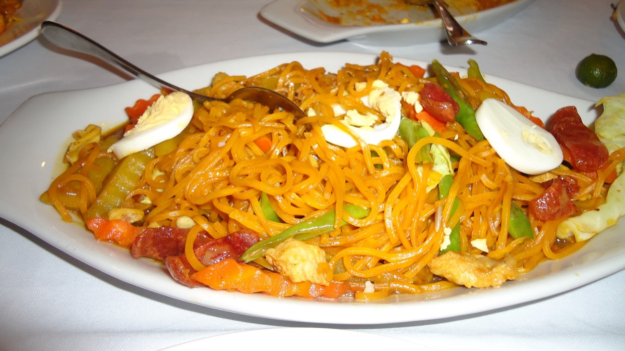 Pancit luglug topped with boiled eggs, shrimp, and chorizo with calamansi