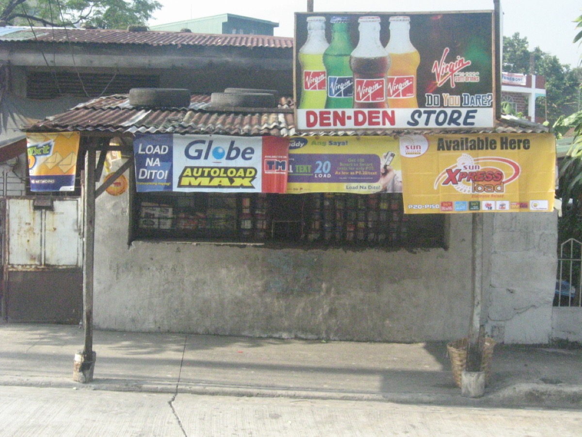 A typical sari-sari store in Quezon City, Philippines — wooden counter, hanging sachets, snack display